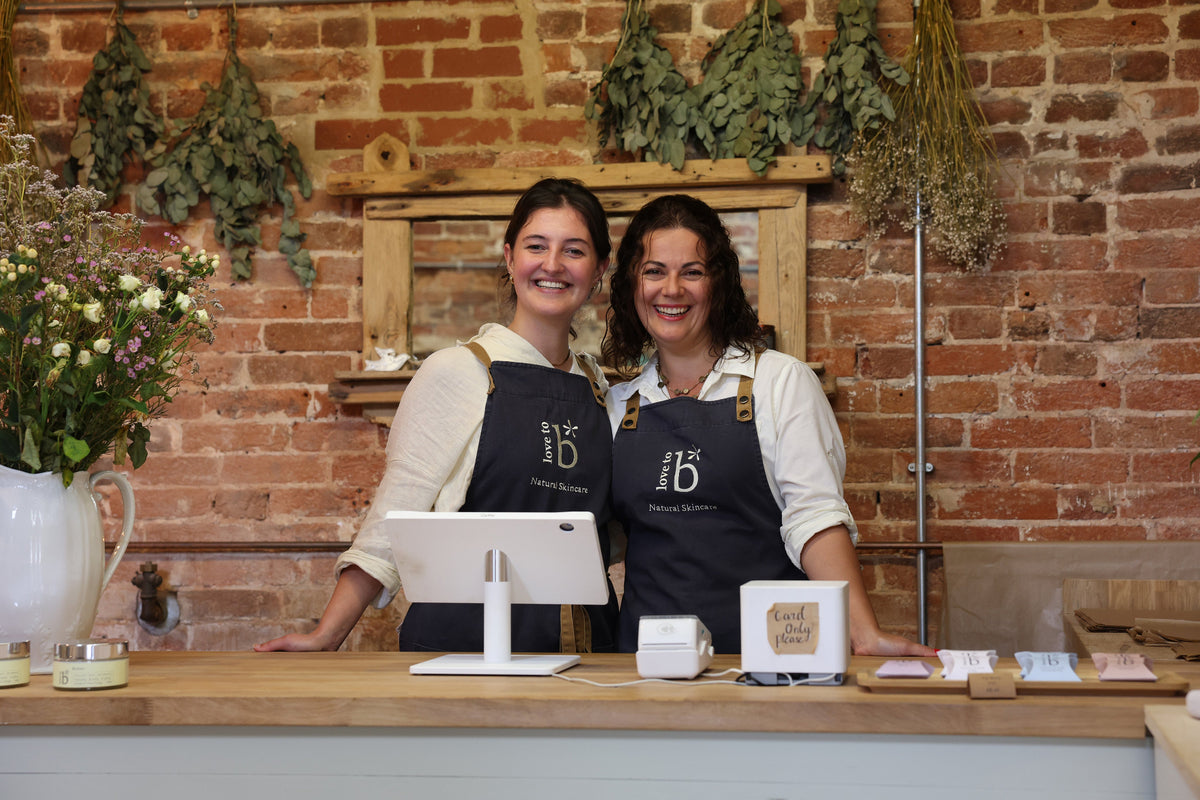 Tw Love to b staff members in the Rngwood store behind the counter smiling towards the camera