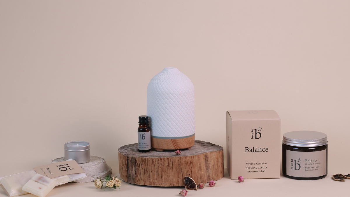 a collection of natural home fragrance products in the scent 'balance' from love to b. This includes a candle jar, diffuser with essential oil blend and soy wax melts