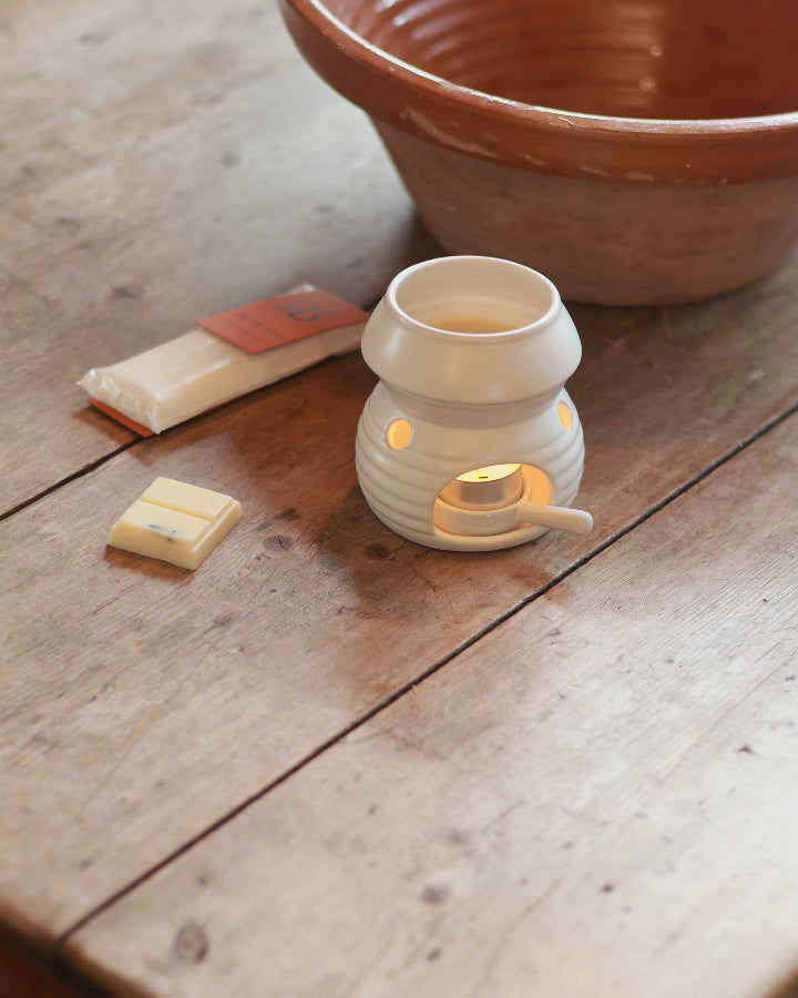 Natural wax bars from Love to b sitting next to a white wax burner